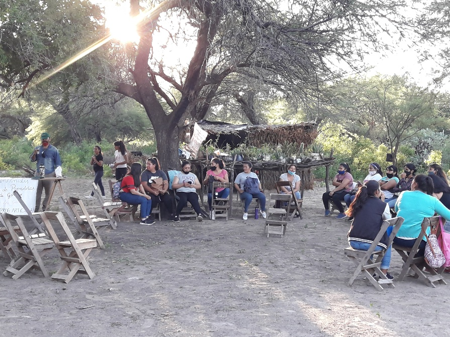 Participantes reunidos en un taller comunitario de género realizado al aire libre.